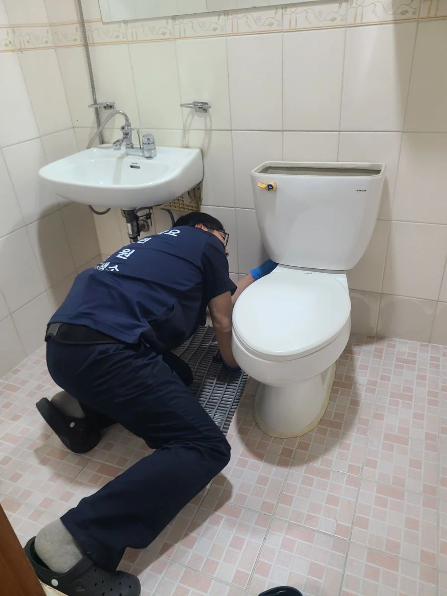물통 덮개를 열고 변기 옆쪽을 점검하는 보관 사진